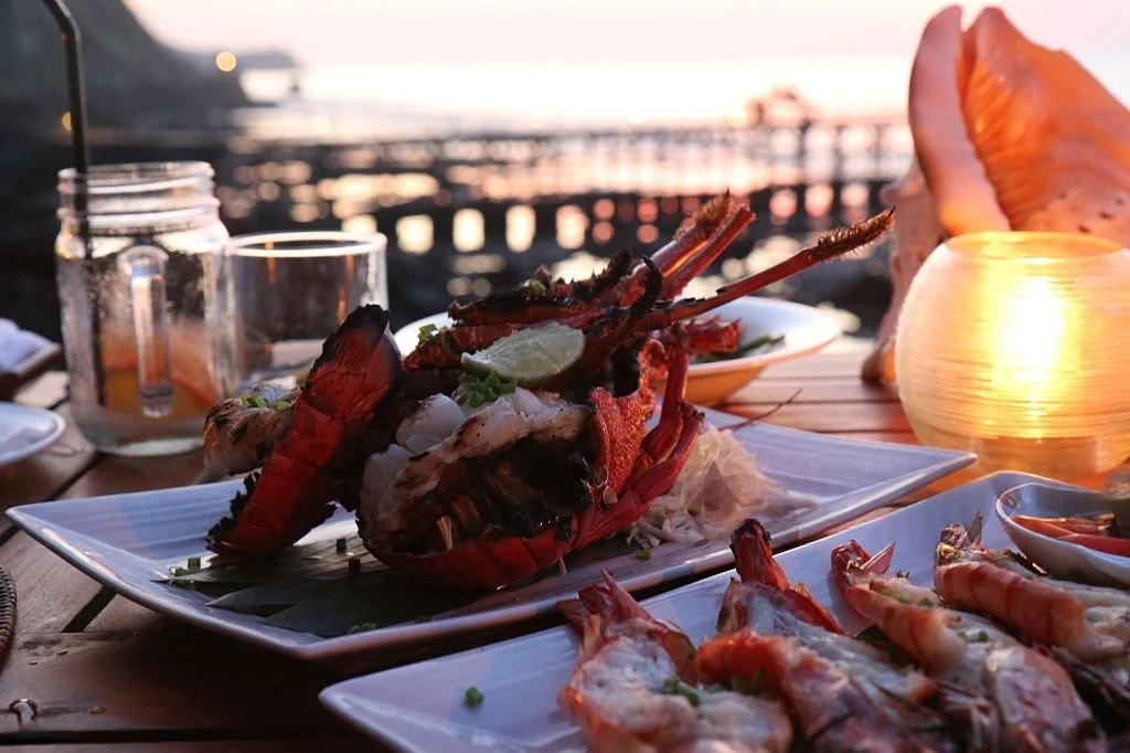 dinner jimbaran romantis dengan sunset di pantai, seafood bakar dan suasana tepi pantai Bali