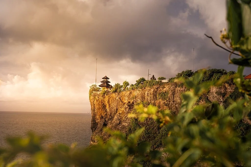 Panorama sunset Pura Uluwatu dengan latar Samudra Hindia dan tebing Bali