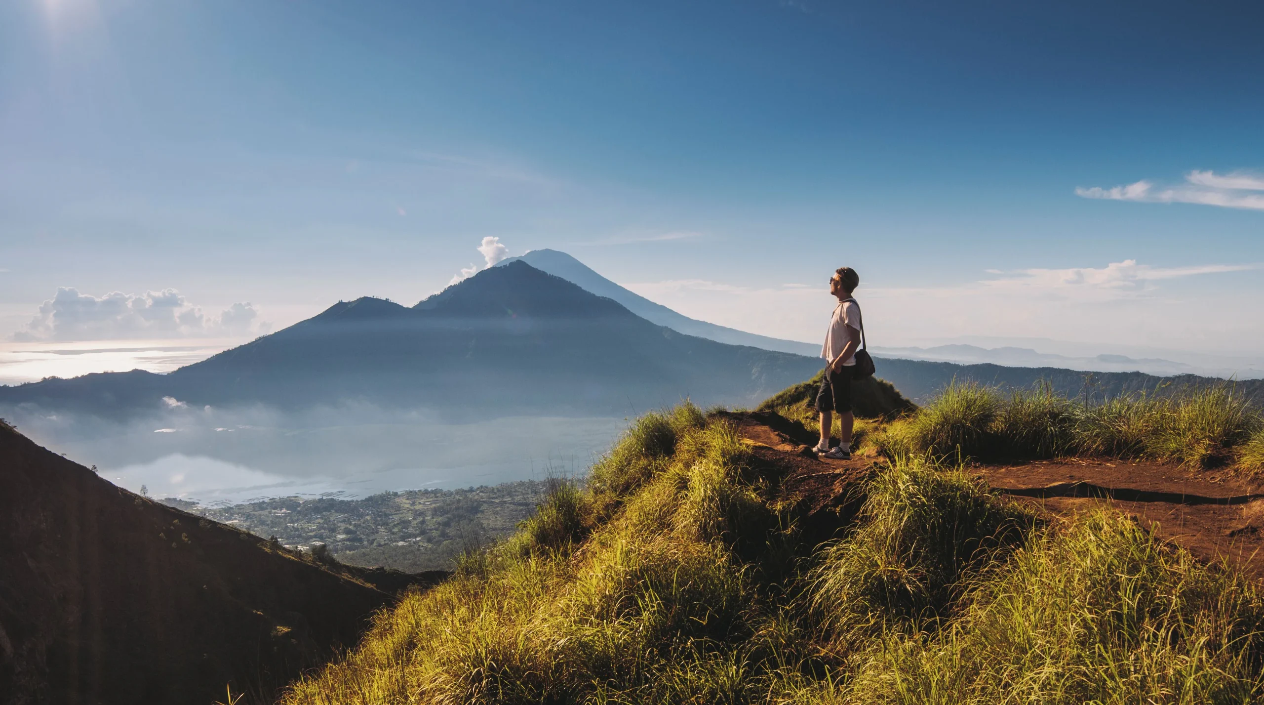 Panorama Gunung Batur Bali saat sunrise dengan latar pegunungan dan kabut pagi